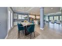 Open-concept dining room with granite table, tile floors, and seamless flow into the living room and kitchen at 6907 Crestpoint Dr, Apollo Beach, FL 33572