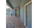 Covered front entryway with brick pavers, leading to a charming front door with decorative glass at 6907 Crestpoint Dr, Apollo Beach, FL 33572