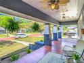 Inviting front porch featuring classic columns, comfortable seating, and a ceiling fan for relaxing outdoors at 714 W Peninsular St, Tampa, FL 33603