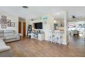 Open-concept living room with a modern entertainment center, neutral colors, and wood-look tile floors at 731 44Th Ne Ave, St Petersburg, FL 33703