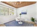Bright dining room features wood plank ceiling, a round table with four chairs, large windows and a blue patterned rug at 747 39Th Ne Ave, St Petersburg, FL 33703