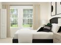 Serene bedroom with a bed dressed in white linens, framed window views, and a large closet for ample storage at 8108 Painted Sky Pl, Land O Lakes, FL 34637