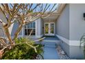 Charming home entryway with double glass doors, tiled steps, and decorative rock landscaping at 9409 Sun Isle Ne Dr, St Petersburg, FL 33702