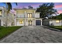 Charming two-story home featuring a stylish exterior, balcony, and a paved driveway at dusk at 1045 Jesse Ave, Safety Harbor, FL 34695