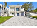 Attractive two-story home showcasing a blue door, balcony, and paver driveway and well-maintained lawn at 1045 Jesse Ave, Safety Harbor, FL 34695