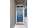 A welcoming blue front door adorned with a floral wreath and a 'HOME' doormat at 10943 Verawood Dr, Riverview, FL 33579