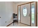 Bright entryway with decorative front door, sidelights, and a small chair with a decorative sign at 1204 Joe Henry Wheeler Dr, Dover, FL 33527