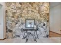 Elegant foyer with a striking stone accent wall, a glass table with artwork, and tile flooring at 1204 Joe Henry Wheeler Dr, Dover, FL 33527
