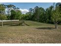 Expansive grassy backyard view with a pond in the distance providing a serene setting at 12308 Chaya Ct, Spring Hill, FL 34610