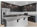 Modern kitchen featuring granite countertops, stainless steel appliances, and dark wood cabinets at 12308 Chaya Ct, Spring Hill, FL 34610
