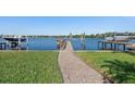 Backyard with a well-maintained lawn, brick walkway leading to a private boat dock at 1344 Monterey Ne Blvd, St Petersburg, FL 33704