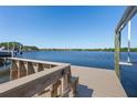 View of a wooden dock and boat lift on the serene waterfront at 1344 Monterey Ne Blvd, St Petersburg, FL 33704