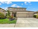Charming two-story home with a three-car garage, green grass, and landscaping at 18185 Cortes Creek Blvd, Spring Hill, FL 34610