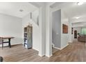 Bright foyer with wood-look tile, staircase, and decorative shelving unit at 18185 Cortes Creek Blvd, Spring Hill, FL 34610