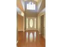 Bright foyer with hardwood floors and a decorative front door at 18724 Geraci Rd, Lutz, FL 33548