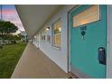 Condominium exterior featuring a teal-painted door with unit number, white walls, and tan walkway at 1900 59Th N Ave # 108, St Petersburg, FL 33714