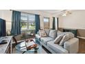 Cozy living room with a plush gray sofa, glass coffee table, and large windows offering natural light at 1900 59Th N Ave # 108, St Petersburg, FL 33714