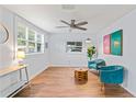 Bright living room boasts luxury vinyl flooring, modern fan, decor, and lots of natural light at 1906 E Idlewild Ave, Tampa, FL 33610