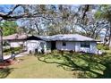 Inviting single-story home featuring a manicured front yard, attached garage, and shaded by mature trees at 2004 Nobleton Ave, Spring Hill, FL 34608