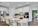 Modern kitchen featuring white cabinets, a large island with seating, and stainless steel appliances at 23231 Scaglione Dr, Lutz, FL 33549