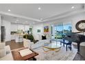 Bright living room with stylish furniture, piano, and sliding glass doors leading to an outdoor view at 23231 Scaglione Dr, Lutz, FL 33549