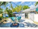 Outdoor patio area with comfortable seating, a fire pit, and well-maintained landscaping at 2700 56Th S St, Gulfport, FL 33707