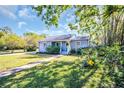 Beautiful home exterior with lush green lawn, manicured garden, concrete walkway and inviting blue front door at 2700 56Th S St, Gulfport, FL 33707