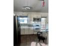 Functional kitchen with stainless steel refrigerator, white cabinets, and tile floor at 3005 W 18Th W Ave, Bradenton, FL 34205