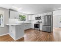 Modern kitchen with stainless steel appliances, white cabinets, and breakfast bar at 3413 N 12Th St, Tampa, FL 33605