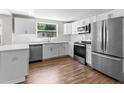 Bright kitchen featuring stainless steel appliances, white cabinetry, and modern finishes at 3413 N 12Th St, Tampa, FL 33605