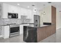 Modern kitchen featuring stainless steel appliances, marble backsplash and a black marble waterfall island at 4812 Wynwood Dr, Tampa, FL 33615