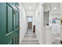 Hallway with blue door leading to updated laundry room, garage access, and stairs at 6343 92Nd N Pl # 2102, Pinellas Park, FL 33782