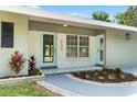 Charming home featuring a painted brick facade, modern front door, and decorative tile entry at 6505 Julie St, Tampa, FL 33610