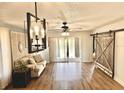 A cozy living room featuring modern lighting, barn door, and sliding glass doors to the outside patio at 717 Cordova Green, Seminole, FL 33777