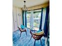 Bright living room with stylish chairs, blue accents, and a large window offering serene views at 717 Cordova Green, Seminole, FL 33777