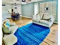 Inviting living room with a cozy sofa, chair, and a vibrant blue rug on light wood flooring at 717 Cordova Green, Seminole, FL 33777