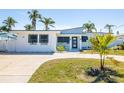 Charming single-story home with a modern design, well-maintained lawn, and palm trees at 728 Pruitt Dr, Madeira Beach, FL 33708