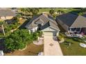 Inviting home with lush landscaping, mature palms, and a spacious driveway in a well-maintained community at 1038 Emerald Dunes Dr, Sun City Center, FL 33573