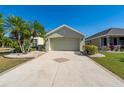 Lovely home with a well-manicured lawn, palm trees, and a patterned driveway, enhancing curb appeal at 1038 Emerald Dunes Dr, Sun City Center, FL 33573