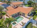Aerial view of a backyard showcasing a swimming pool, spa, lounge chairs, and a privacy fence at 1140 81St S St, St Petersburg, FL 33707