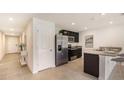 Modern kitchen with stainless steel appliances, dark cabinets, granite countertops and an island with seating at 1210 Cape Chestnut Pl, Ruskin, FL 33570