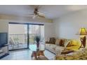 Living room with access to balcony, with ceiling fan and tile floors creates a comfortable space at 12924 Gulf Blvd # 310, Madeira Beach, FL 33708