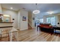 Open-concept living space with wood floors, modern lighting, and a view of the staircase at 13217 Canopy Creek Dr, Tampa, FL 33625