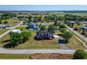 Expansive aerial view of a red two-story home with lush landscaping and ample surrounding acreage at 14807 Capps Estates Ln, Wimauma, FL 33598