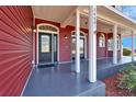 Inviting front porch featuring black framed doors, and columns along the walkway at 14807 Capps Estates Ln, Wimauma, FL 33598