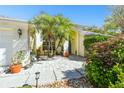 Welcoming front yard featuring mature palm trees, lush landscaping, and a paver patio at 15018 Greeley Dr, Tampa, FL 33625
