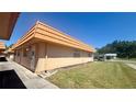 Side view of a peach-colored home with a well-maintained lawn, offering a glimpse of the serene neighborhood at 1801 Bedford Ln # 46, Sun City Center, FL 33573
