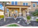 Charming front porch with decorative plants, furniture, and hanging baskets, perfect for relaxing at 21832 Crest Meadow Dr, Land O Lakes, FL 34637