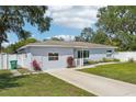 Charming single-story home with well-manicured lawn, concrete driveway, and a white privacy fence at 2362 Mary Ln, Clearwater, FL 33763