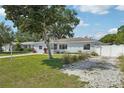 Inviting single-story home with mature trees, well-kept lawn, and a quaint gravel driveway at 2362 Mary Ln, Clearwater, FL 33763